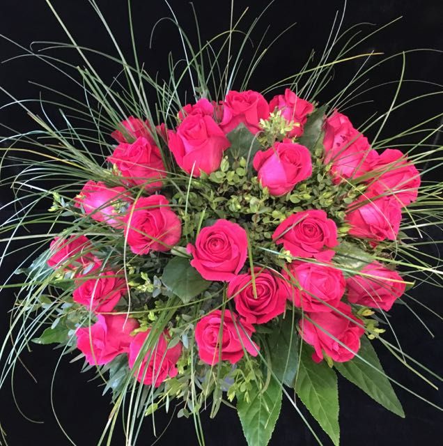 Runder Strauß aus pinken Rosen mit Gräsern