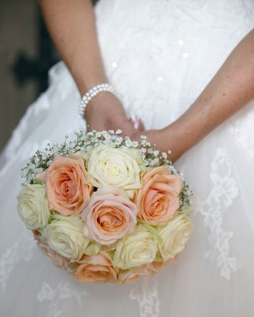Braut mit Brautstrauß aus Rosen in Apricot und Weiß