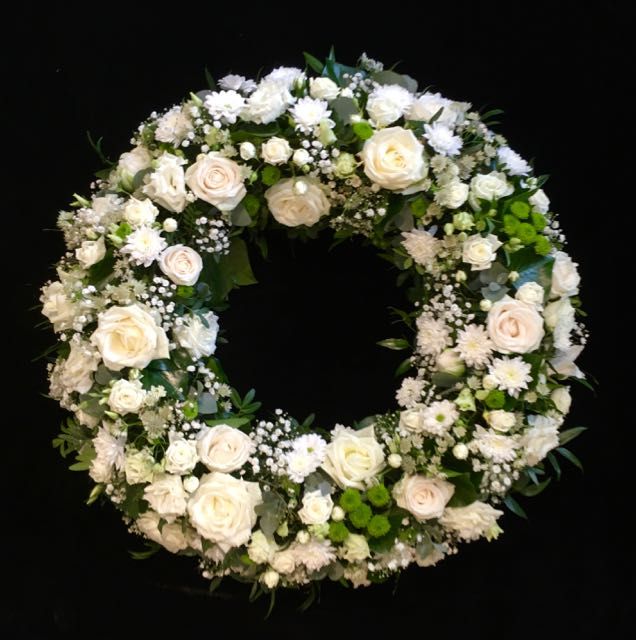 Trauerkranz aus weißen Rosen und Nelken